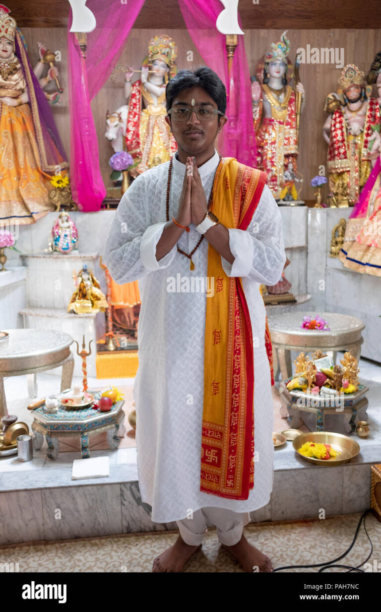 posed portrait of a teenage pandit at a youth service at the milan mandir hindu temple in south ozone park queens new york PAH7NC 768x1233